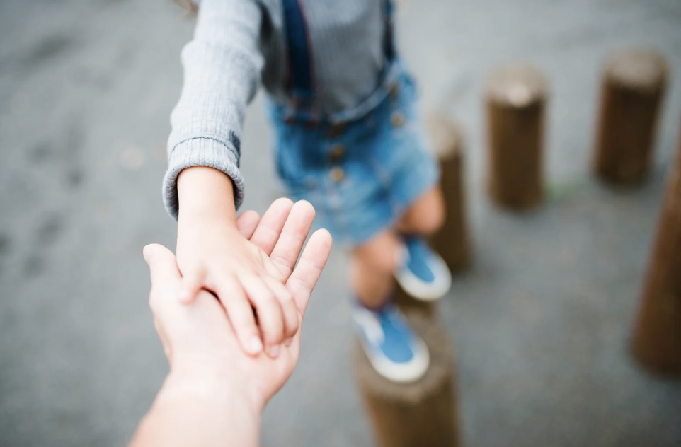 parents holding child's hand